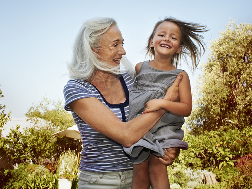 Grandmother holding granddaughter smiling at camera